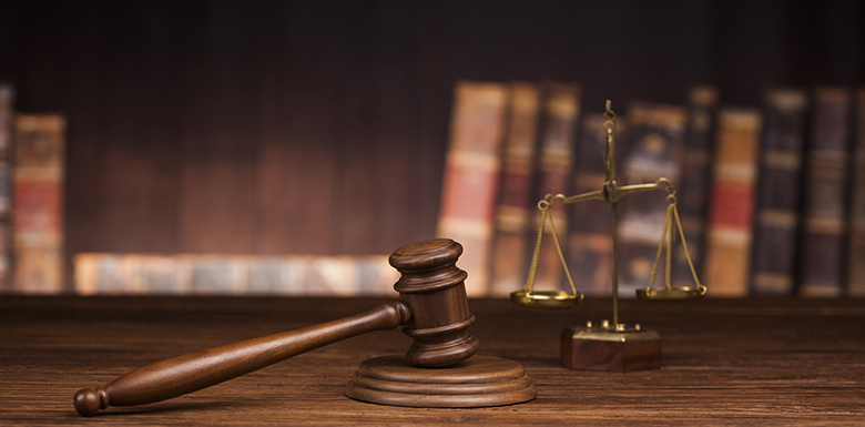 Gavel on stand in front of legal books