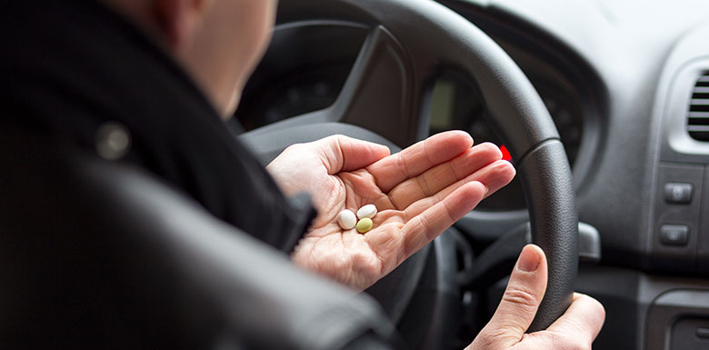 Man holding pills in a car image