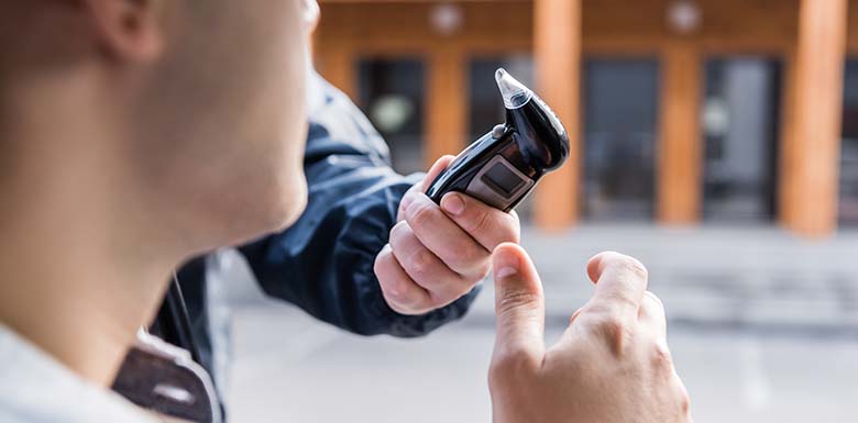 Police officer handing driver breathalyzer