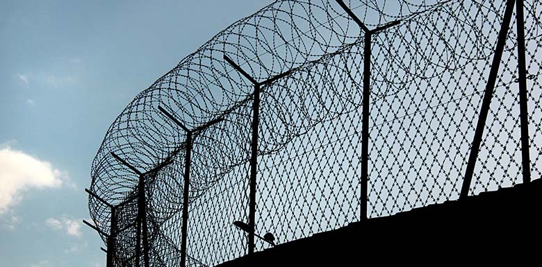 Prison barbed wire against the sky