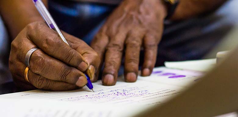 Person filling out form with purple pen